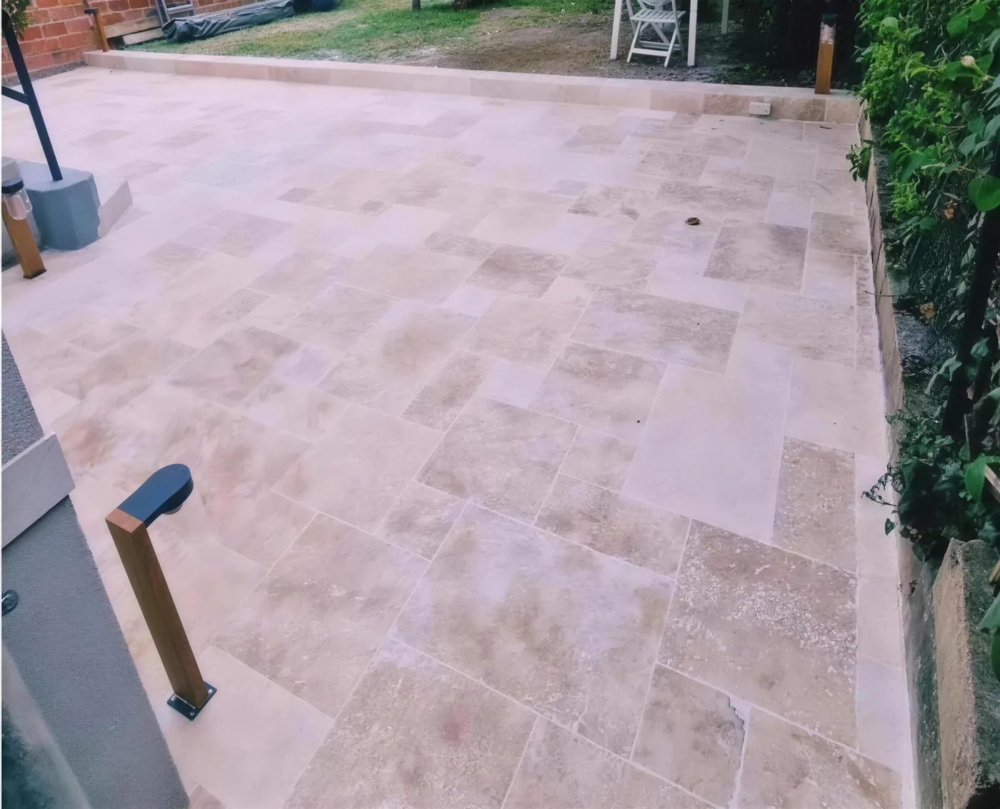 Terrasse en travertin et jardin paysagé réalisés par TTS Rénovation