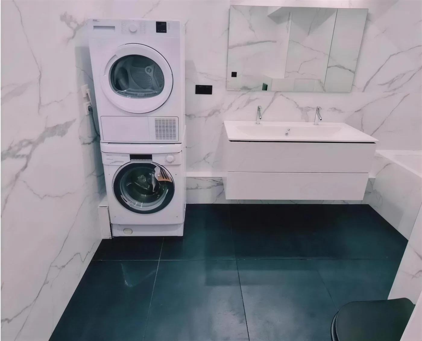 Salle de bain en marbre avec meuble double vasque, réalisée par TTS Rénovation